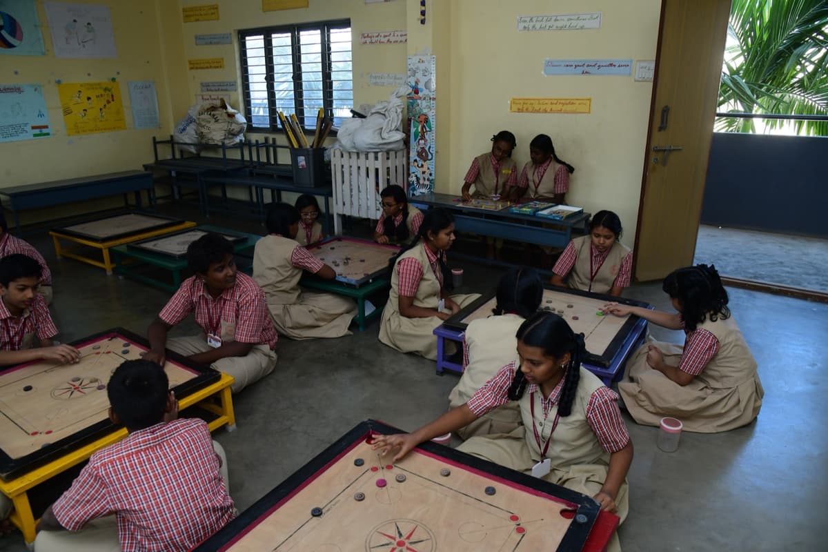 Students playing carrom in the indoor games area